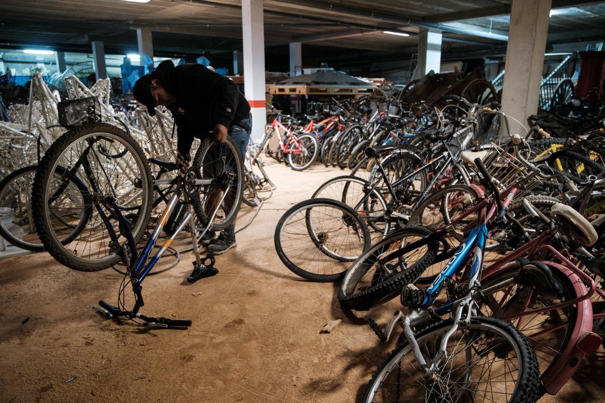 Un hombre repara una de las bicicletas donadas