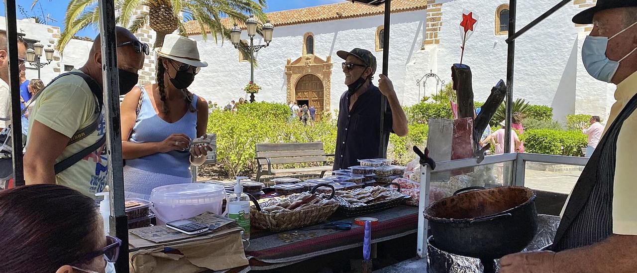 Jacinto Ruiz atiende a dos clientes en la plaza Santa María de Betancuria. | | LP/DLP