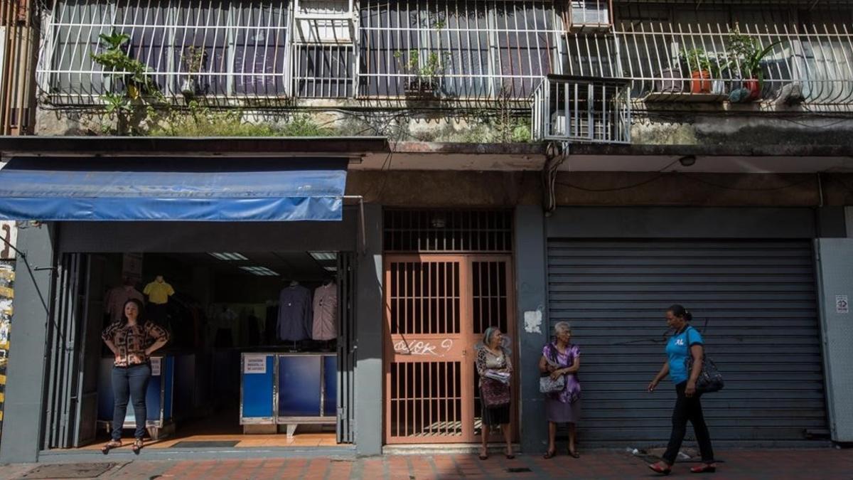 Un comercio abierto y otro cerrado en una calle de Caracas