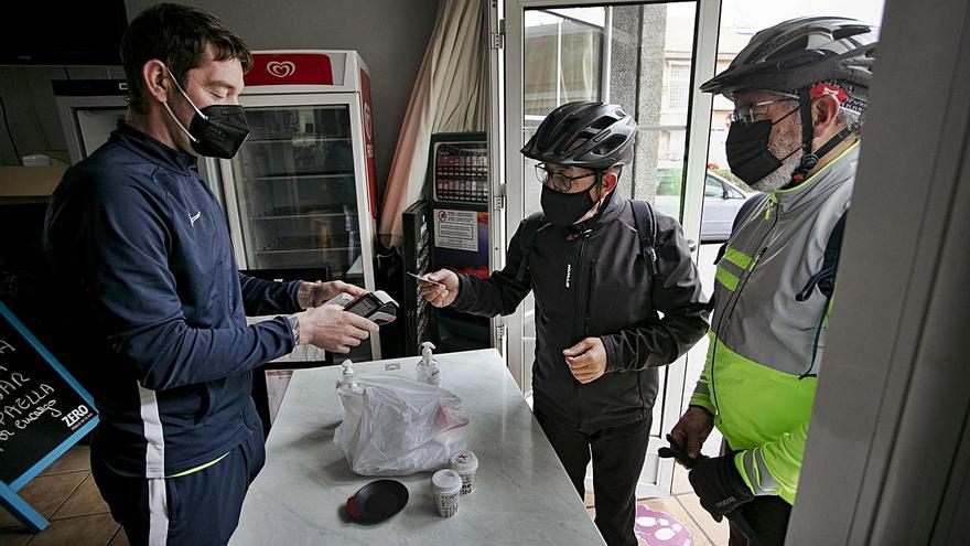 Un trabajador de un bar del Port de Sagunt, repartiendo ayer comida para llevar. | DANIEL TORTAJADA