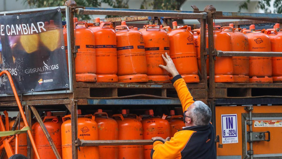 Un hombre intenta coger una bombona de butano