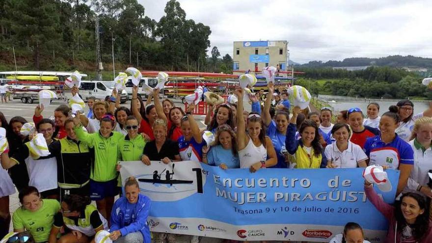 Las piragüistas posan con el cartel del evento.