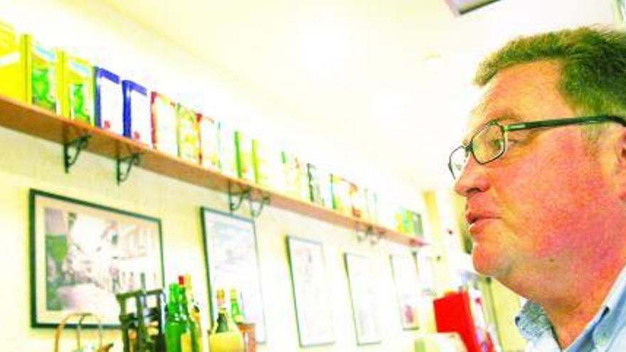 Carlos Vílpido, con la colección de latas de aceite que guarda en su restaurante.