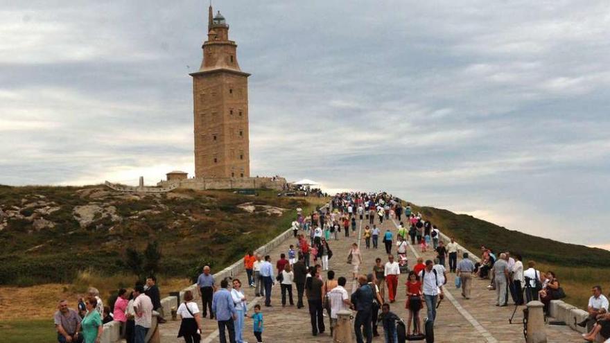 Vecinos de A Coruña y turistas visitan la Torre de Hércules.