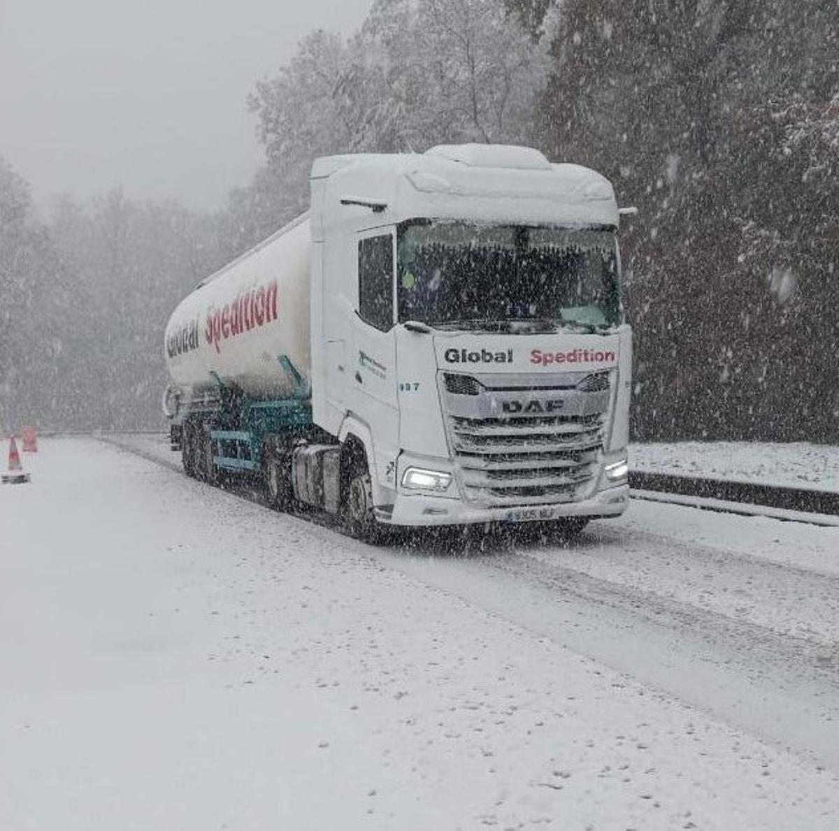 Un camión avanza en medio de una tormenta de nieve
