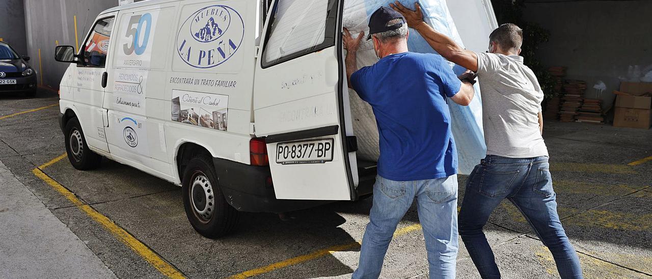 Empleados de Muebles La Peña, cargando enseres para un reparto