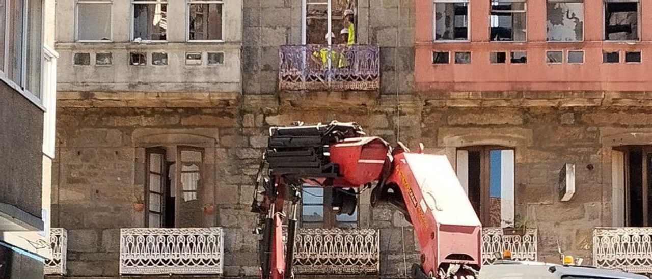 Operarios en la segunda planta del inmueble quemado.