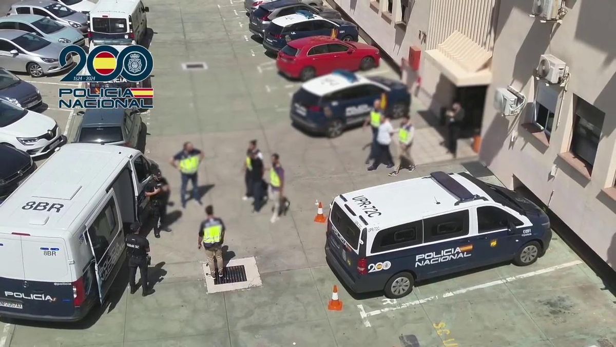 Traslado de dos detenidos a un furgón policial