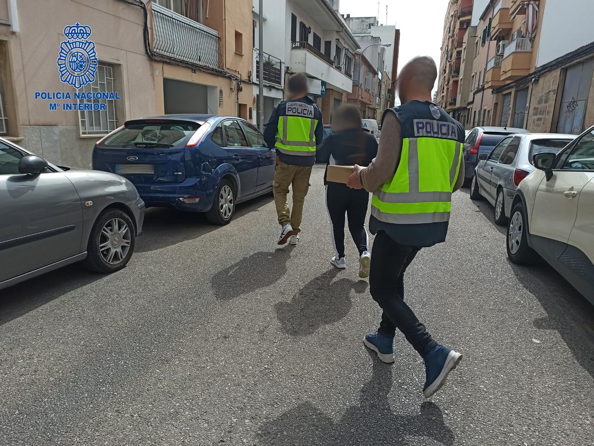 Agentes de la Policía con uno de los acusados.