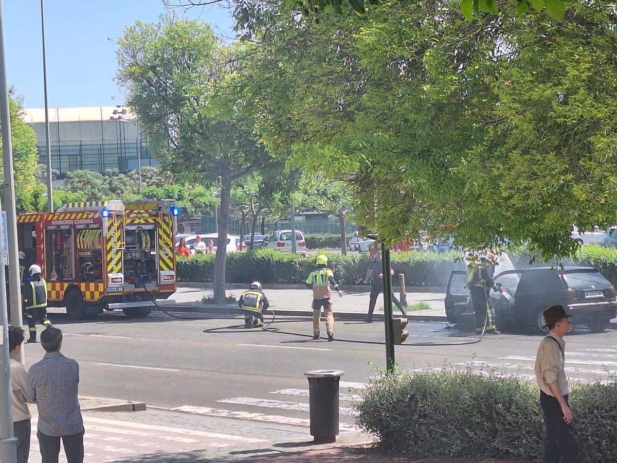 Bomberos de Córdoba extinguen el incendio que ha calcinado un coche.