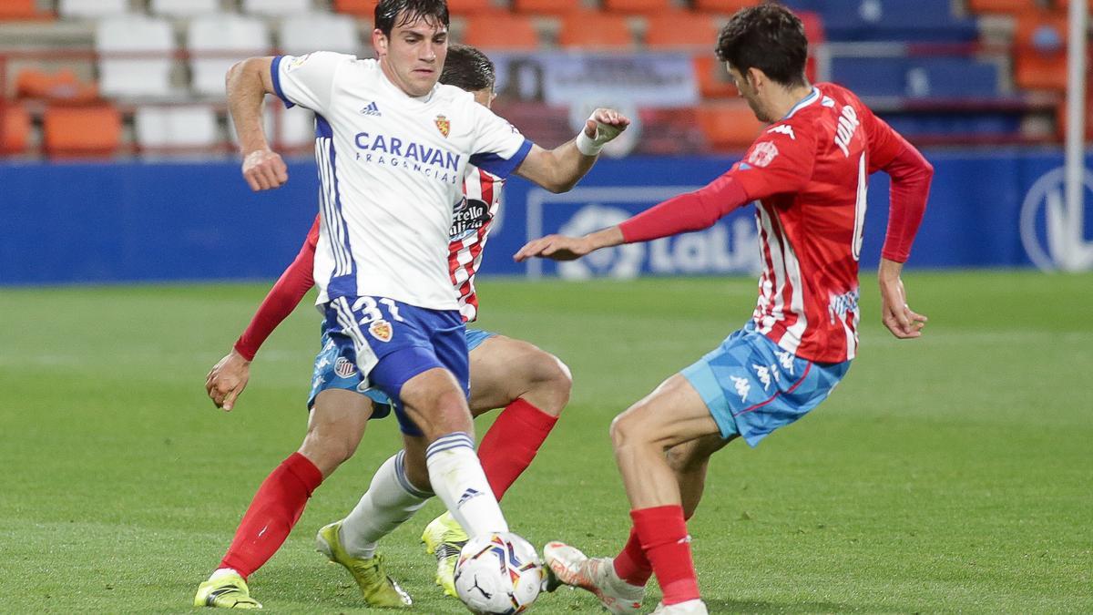 Azón pugna con dos jugadores del Lugo en el partido de la pasada campaña disputado en el Anxo Carro.
