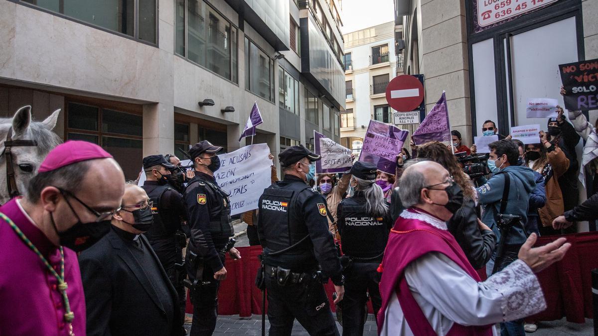 Munilla a su paso frente a un grupo con carteles en defensa de la mujer