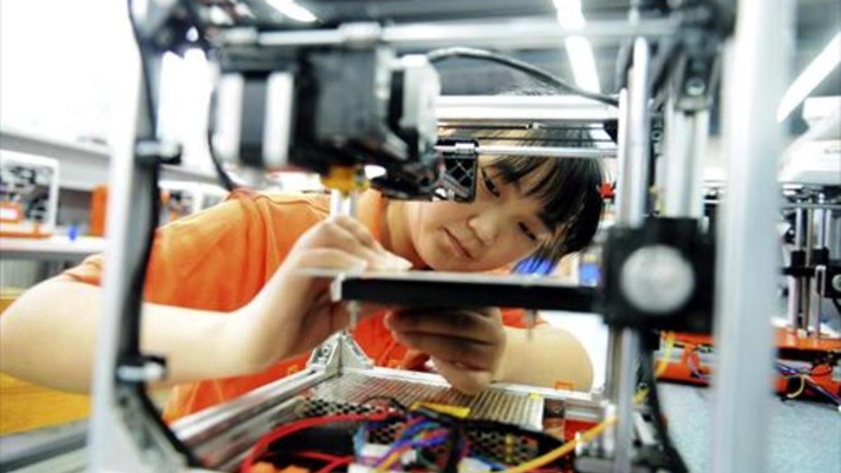 Una trabajadora ensambla una impresora en 3D en Qindao.