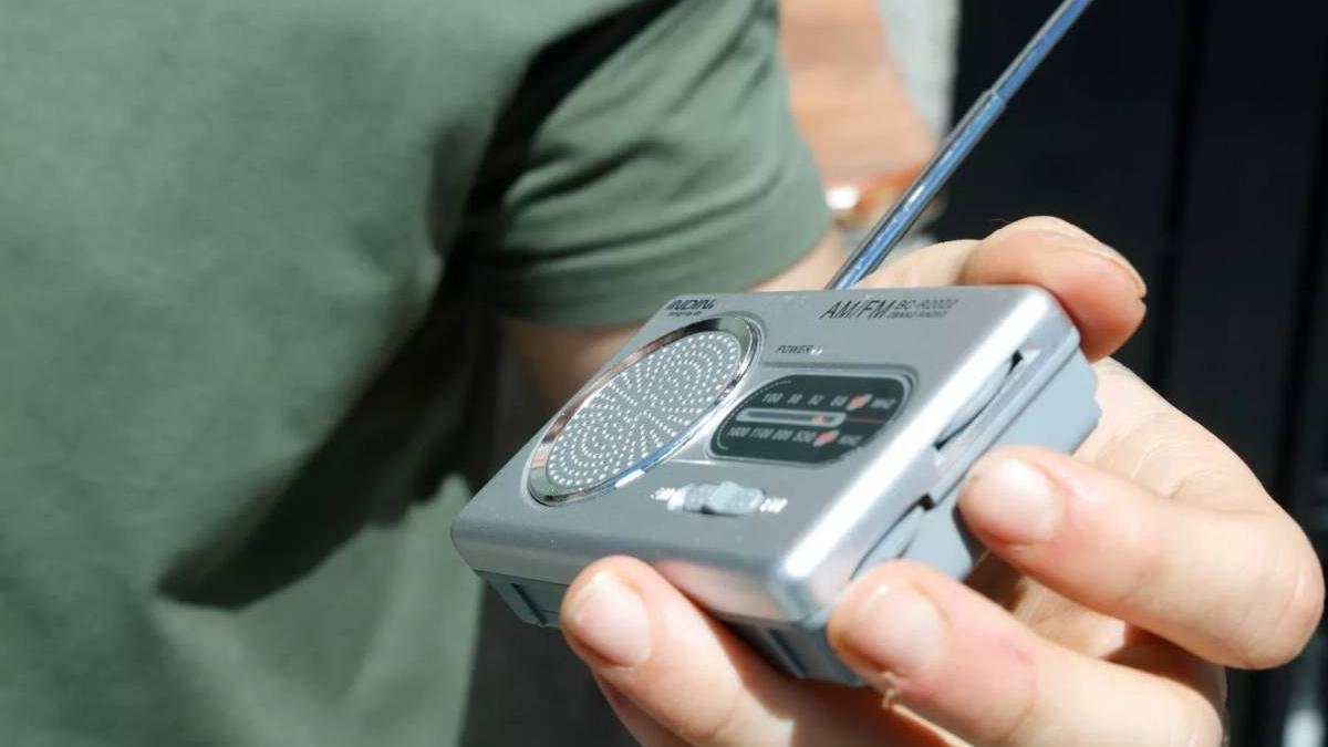 Una persona escucha una radio que funciona con pilas.