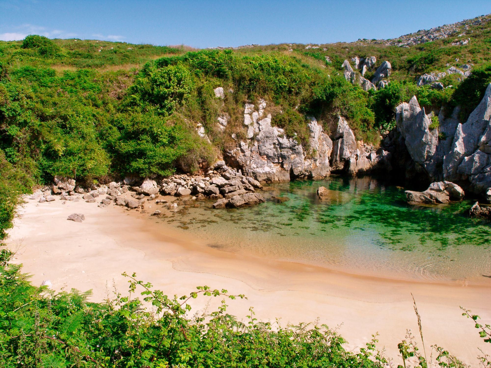 La playa de Gulpiyuri rodeada de verdes acantilados