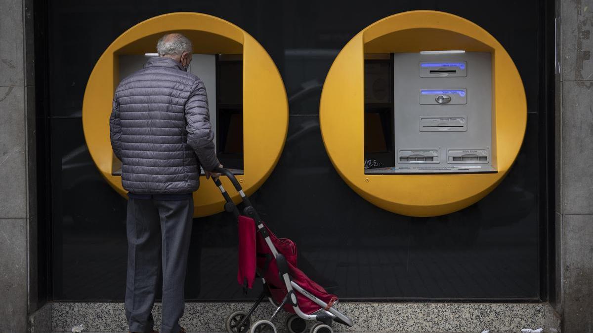 Un jubilado delante de un cajero automático, en Barcelona.