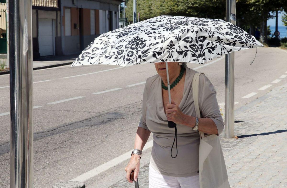 Una mujer se protege del sol con un paraguas, ayer en el entorno de Alcabre, en Vigo. | Marta G. Brea
