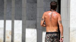 Un hombre camina de espaldas por la zona de la Vila Olímpica de Barcelona, en agosto pasado.