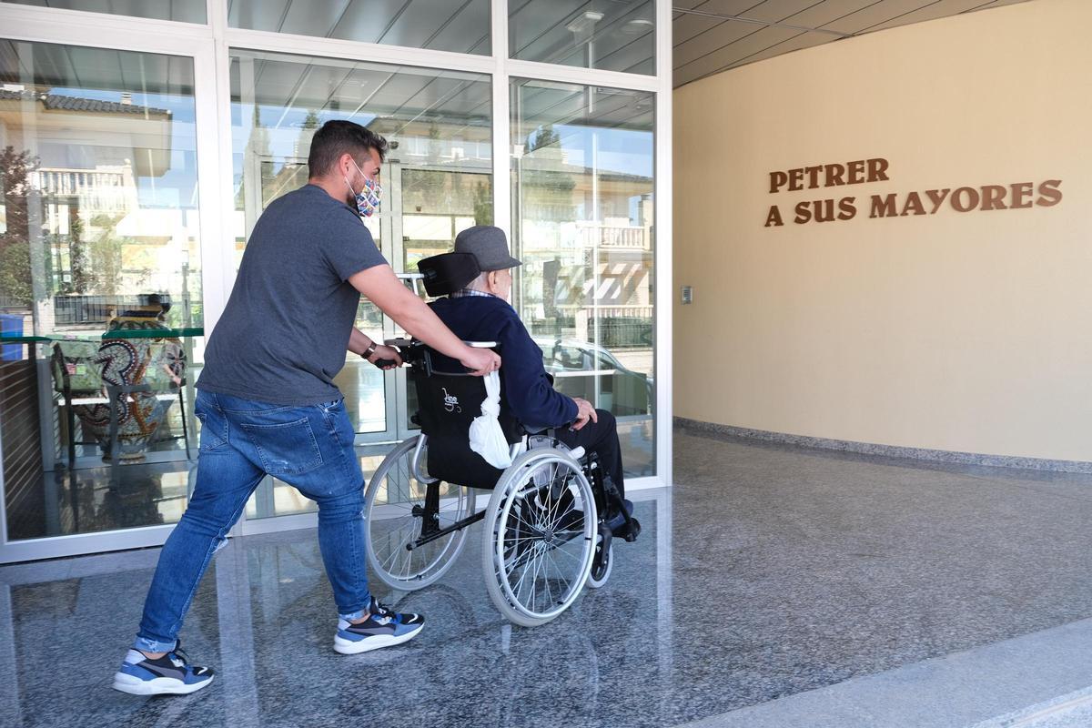 Un residente de La Molineta de Petrer en el acceso al centro acompañado por un familiar.