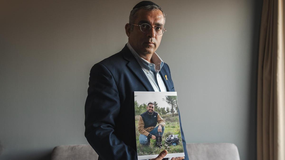 Elhanan Danino, padre de un secuestrado por Hamás, muestra una foto de su hijo.