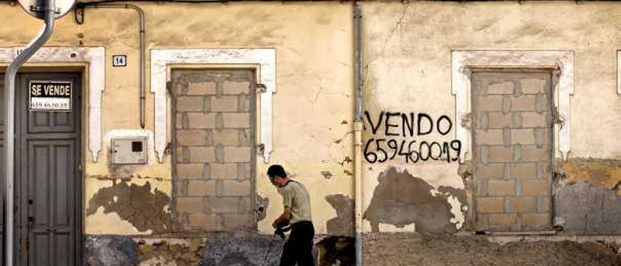 Un vecino pasa por la zona donde se pueden apreciar las puertas tapiadas.