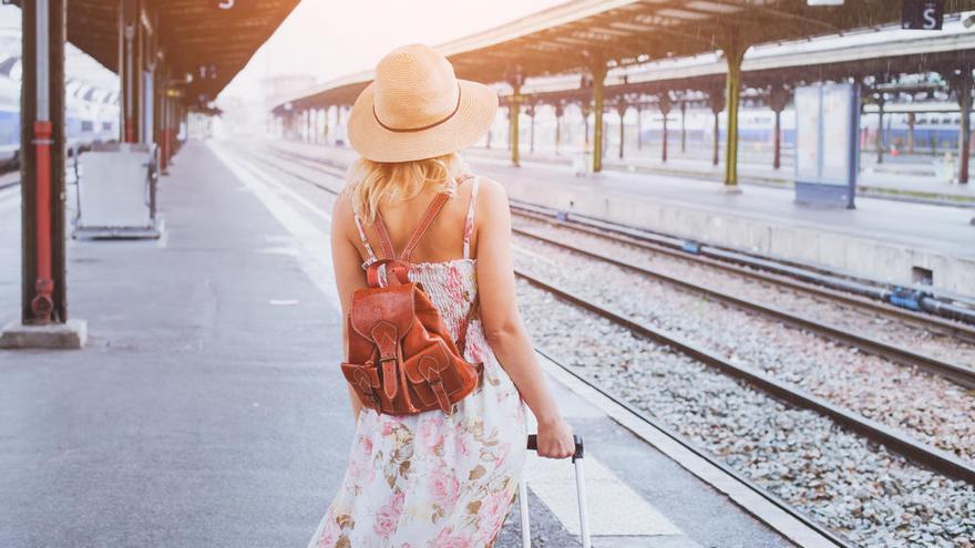 Una mujer espera un tren en el andén.