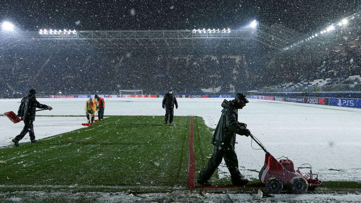 08 December 2021, Italy, Bergamo: Workers remove the snow from the pitch ahead of the UEFA Champions League Group F soccer match between Atalanta BC and Villarreal CF at Gewiss Stadium. Photo: Francesco Scaccianoce/LPS via ZUMA Press Wire/dpa Francesco Scaccianoce/LPS via ZU / DPA 08/12/2021 ONLY FOR USE IN SPAIN