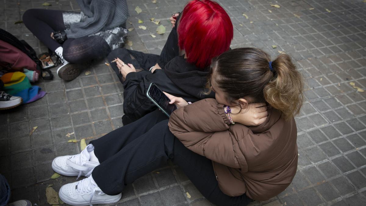 Un grupo de adolescentes a la puerta de un instituto.