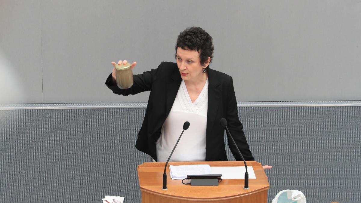 María Marín muestra un bote con agua del Mar Menor durante el Debate del Estado de la Región.