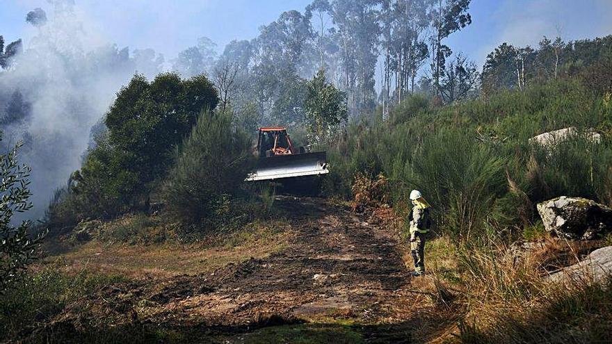 Un helicóptero descarga agua en el incendio de Augasantas.