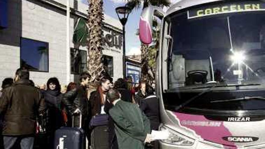 Pasajeros subiendo a un autobús junto a la Estación.