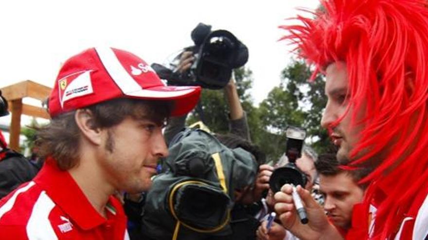 Fernando Alonso firma un autógrafo a un aficionado en Australia.