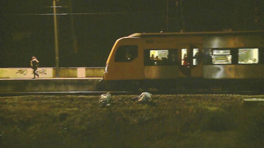Los cadáveres de dos de las víctimas, ante un tren de pasajeros. // CMTV/Correio da Manhã