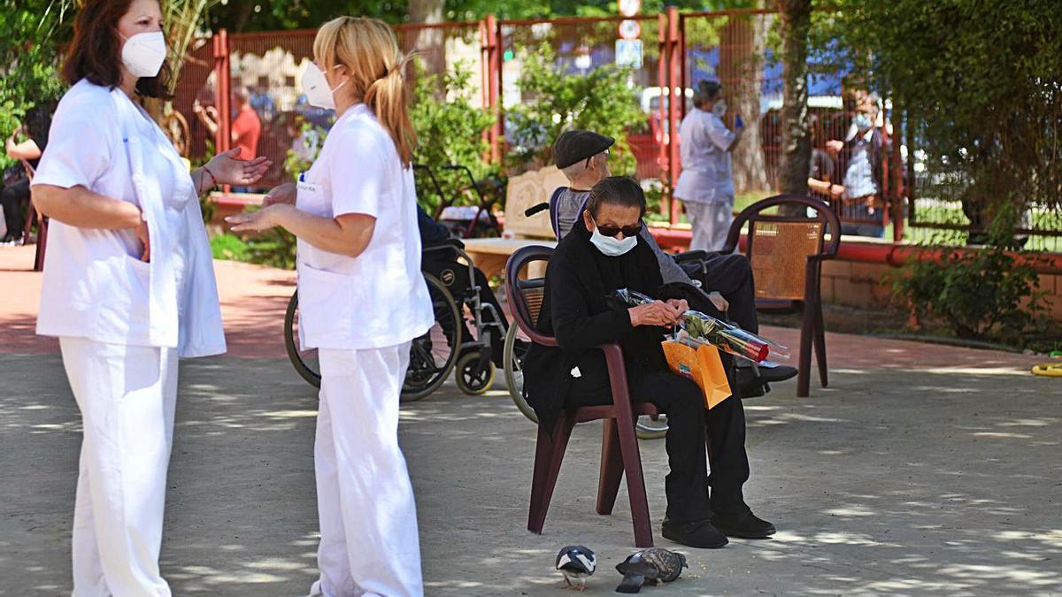 Dos trabajadoras charlan en la zona al aire libre de una residencia en San Basilio, Murcia.