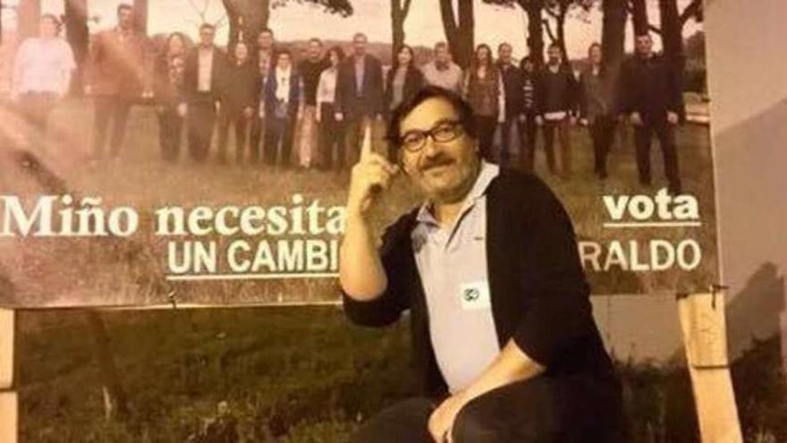 El alcalde, en su posado junto a un cartel de sus excompañeros del PSOE tras obtener un edil en las elecciones.