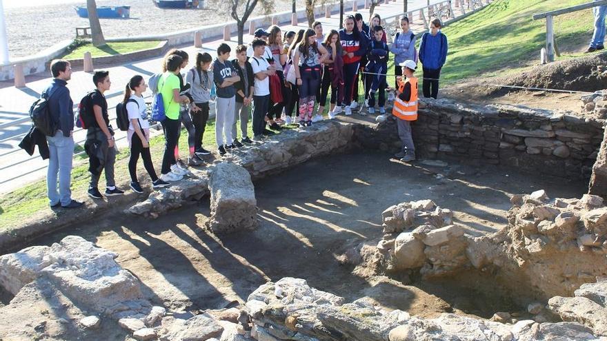 Un grupo de escolares atiende las explicaciones de uno de los arqueólogos en la ciudad romana de Suel.
