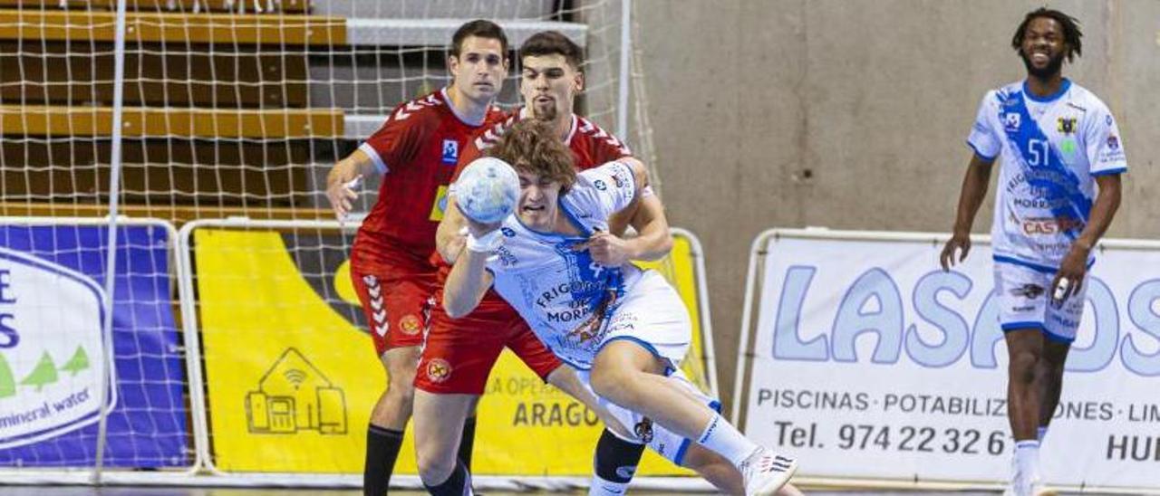 Brais González es defendido por un rival en el partido entre Huesca y Frigoríficos del Morrazo. |  // ANDREY SAPIZHAK