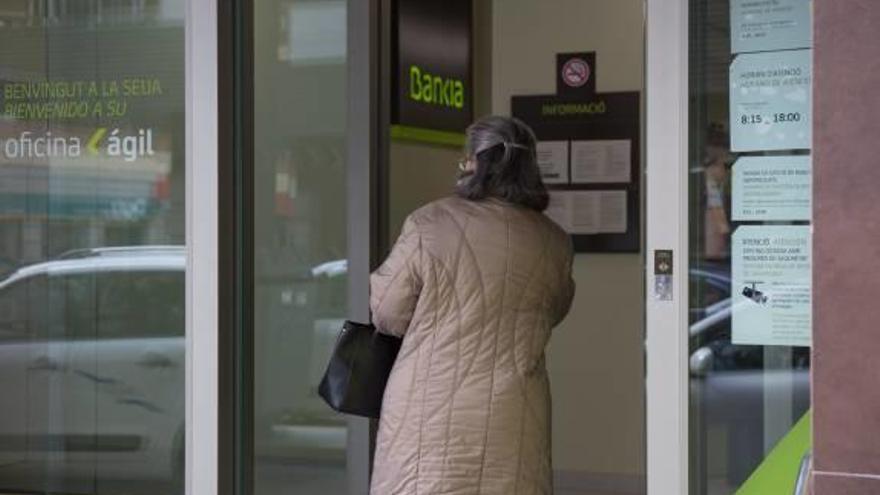 Una clienta entra en una oficina de Bankia en Alicante.