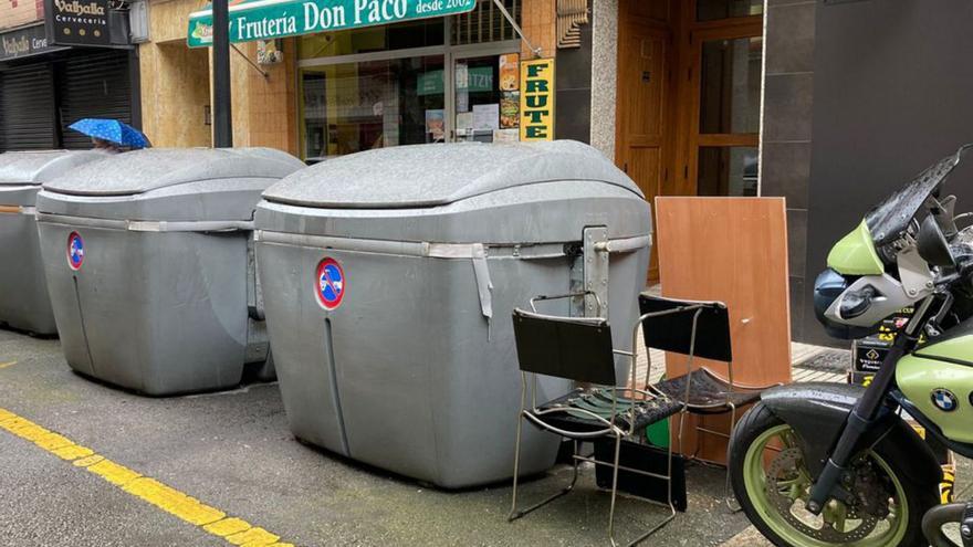 Mobiliario depositado junto a contenedores de basura, ayer, en la calle Premio Real de Gijón.