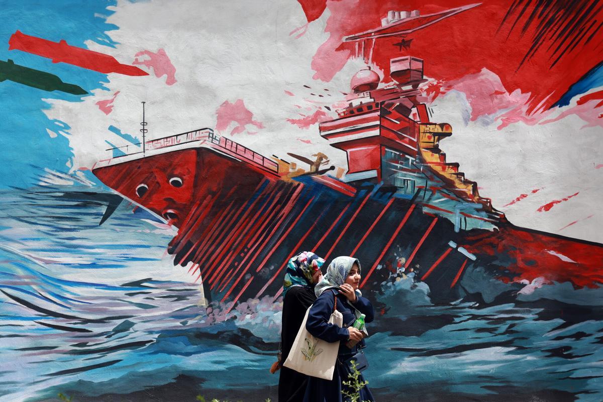 Unos iraníes caminan junto a un mural contra Estados Unidos en una calle de Teherán, Irán, el 4 de mayo de 2026.