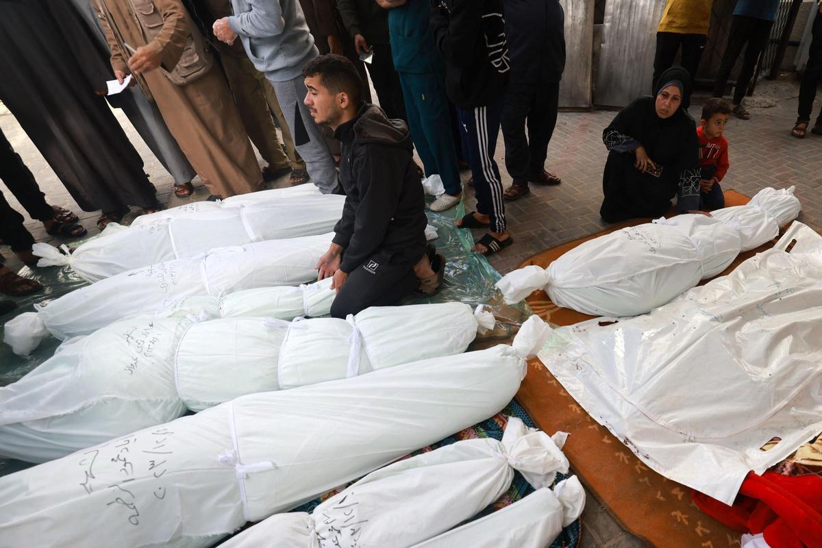 La gente se reúne para identificar los cuerpos de los familiares muertos en los ataques israelíes en Rafah, en el sur de la Franja de Gaza, en el hospital de al-Najjar el 1 de diciembre de 2023, después de que se reanudaran las batallas entre Israel y el movimiento Hamás.