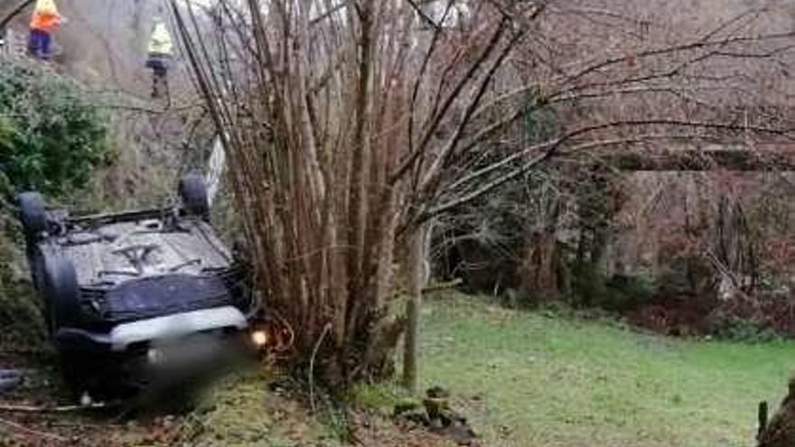 El coche volcado en Proaza.