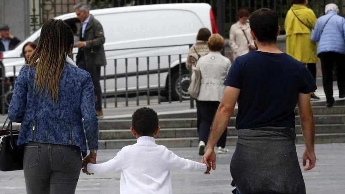 Un niño paseando con sus padres.
