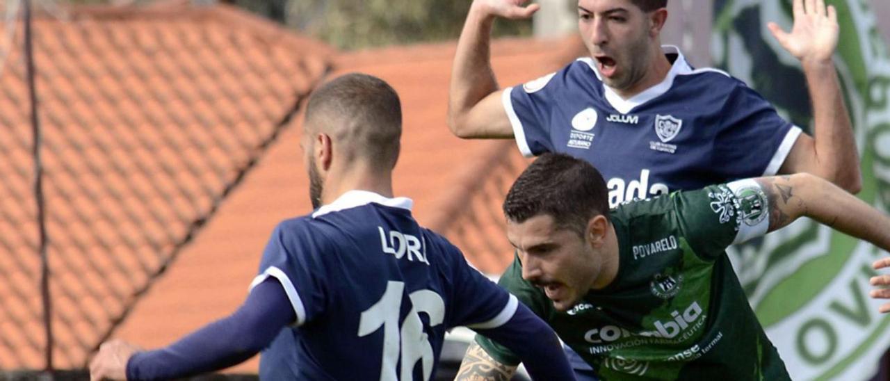 Lora y Guille Pinín disputan el balón con un jugador del Arenteiro. |