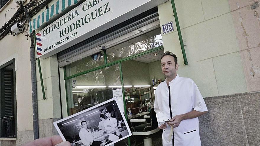 Vicente Rodríguez con la foto de su padre y el socio de este en la barbería. 