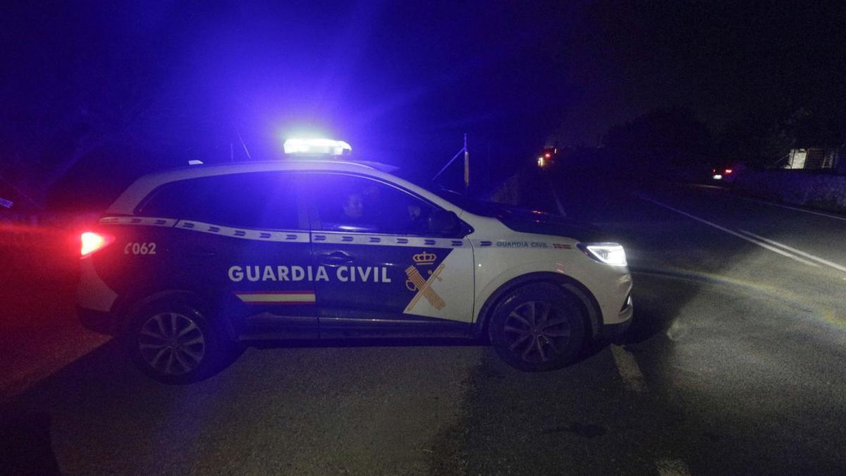 Un coche de la Guardia Civil abandona el lugar donde se hallaron los cuerpos.  | M.M.