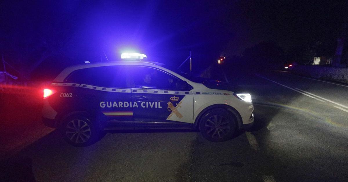 Un coche de la Guardia Civil abandona el lugar donde se hallaron los cuerpos.  | M.M.