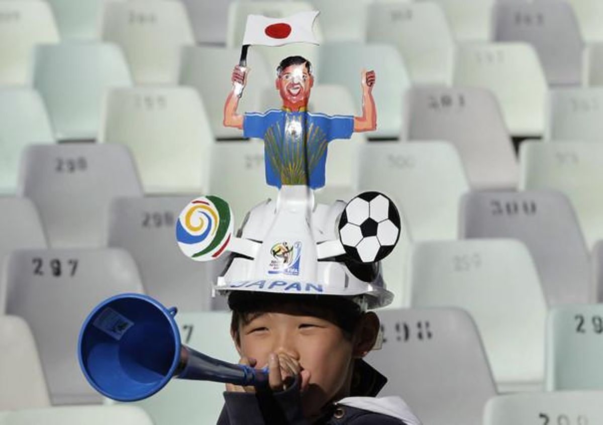 Un japonès bufa en una vuvuzela, instrument de moda a Sud-àfrica aquests dies.