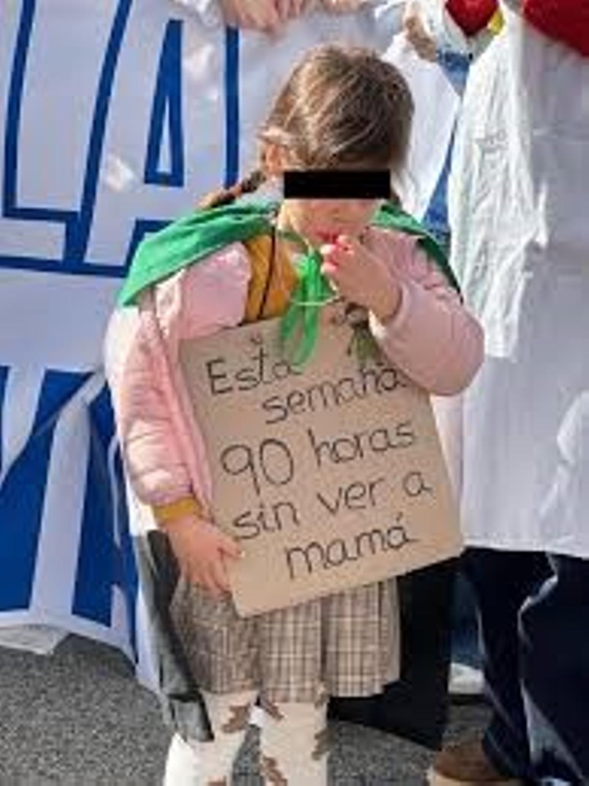 Una niña sostiene un cartel en una protesta de los médicos.