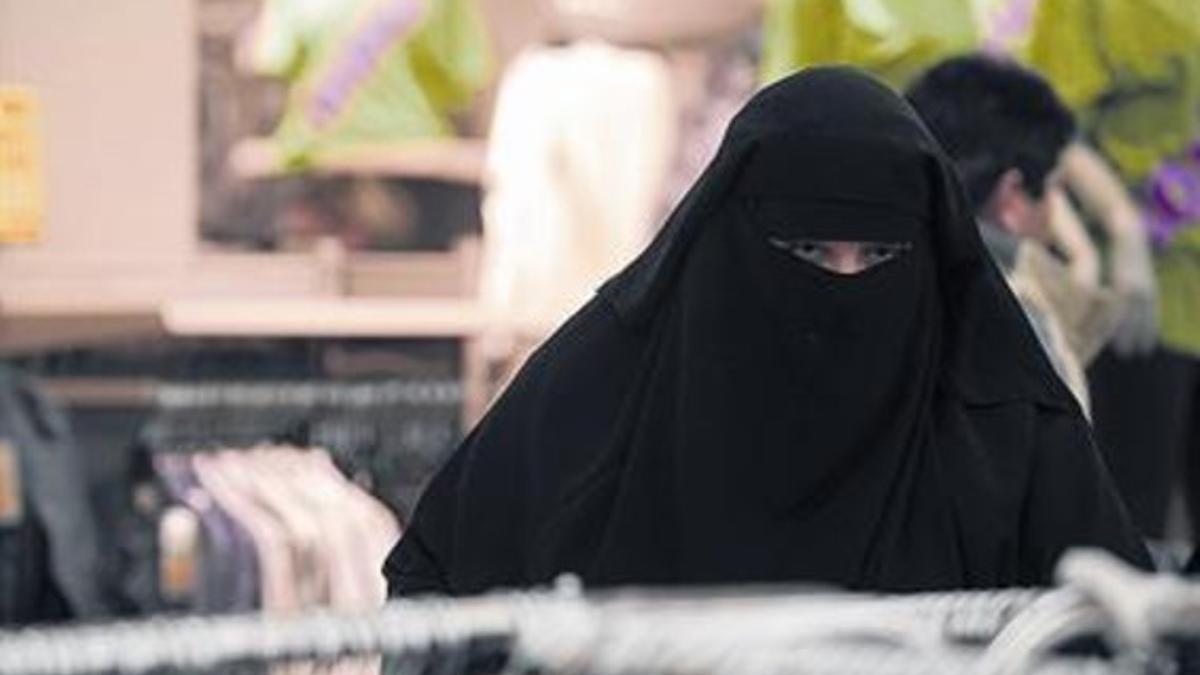 Una mujer con burka compra en un supermercado del norte de Francia.